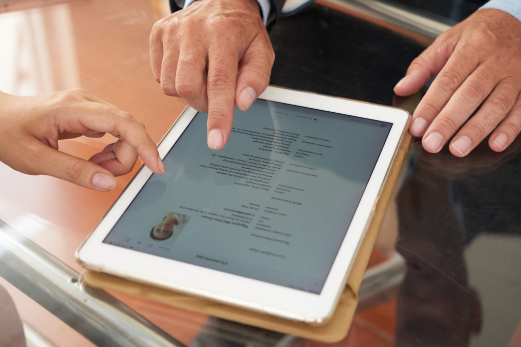 Business people watching resume online on tablet at the table